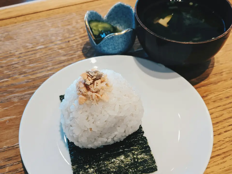Onigiri på ett ark sjögräs med en skål misosoppa bredvid